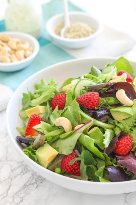 Strawberry Avocado Salad with Hemp Tahini Dressing - A bright and sunny salad for summer, loaded with superfoods and tossed in a creamy, dairy-free tahini hemp dressing. Pair it with your protein of choice for a complete meal. Recipe via Eat Spin Run Repeat // @eatspinrunrpt